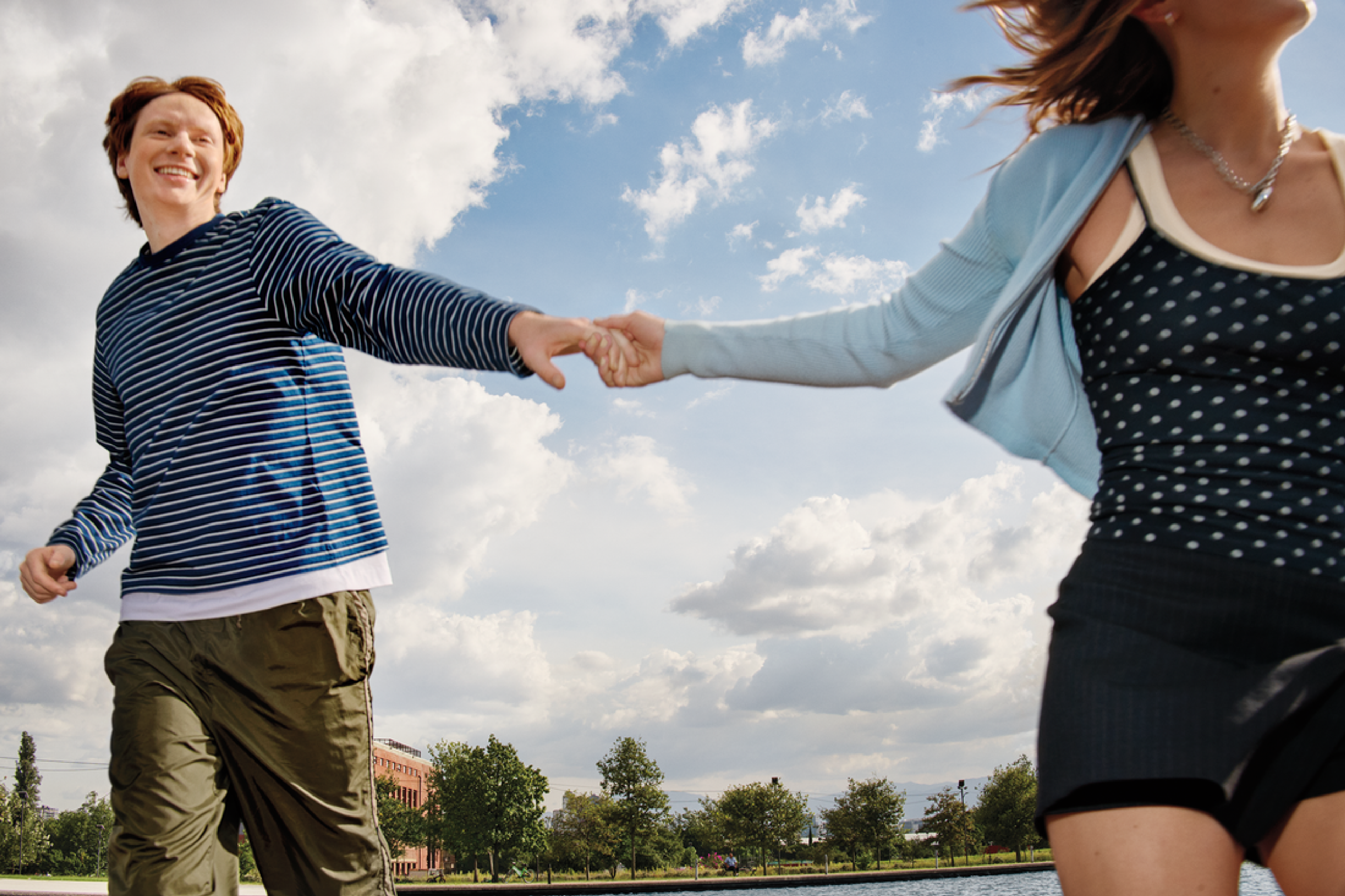 Couple running by a lake, holding hands