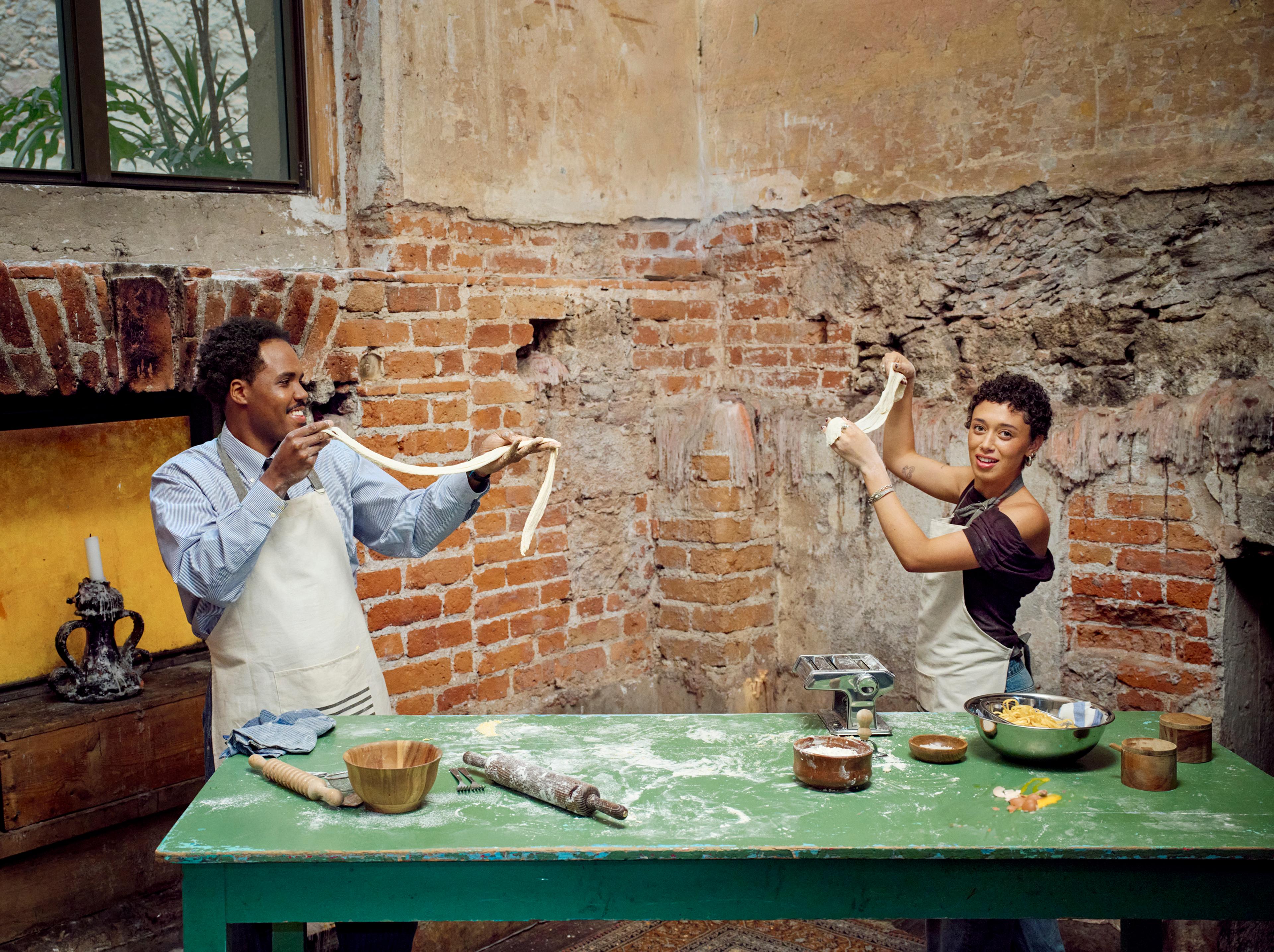 Two people standing up and making dough together (mobile)