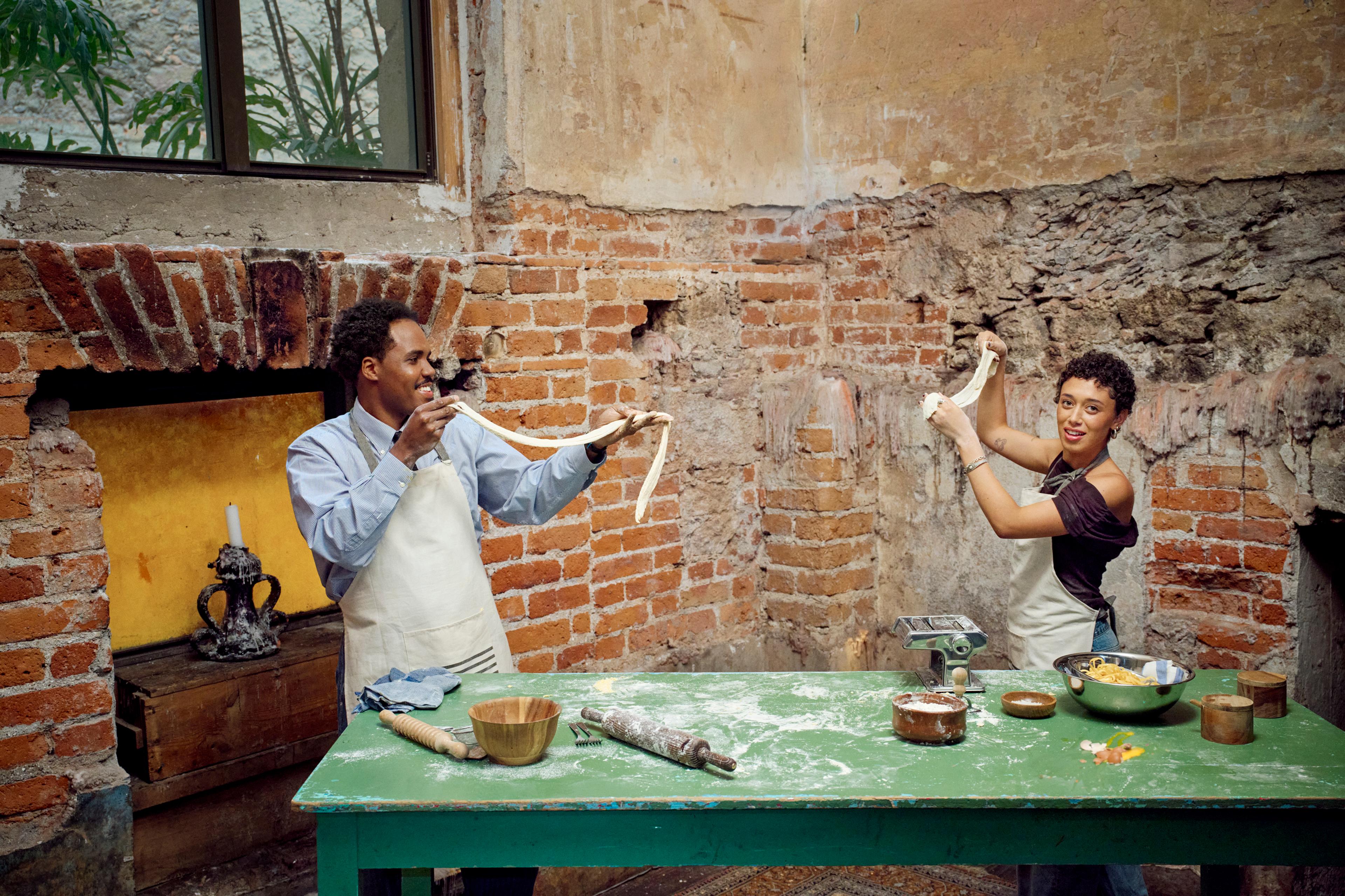 Two people standing up and making dough together (mobile)