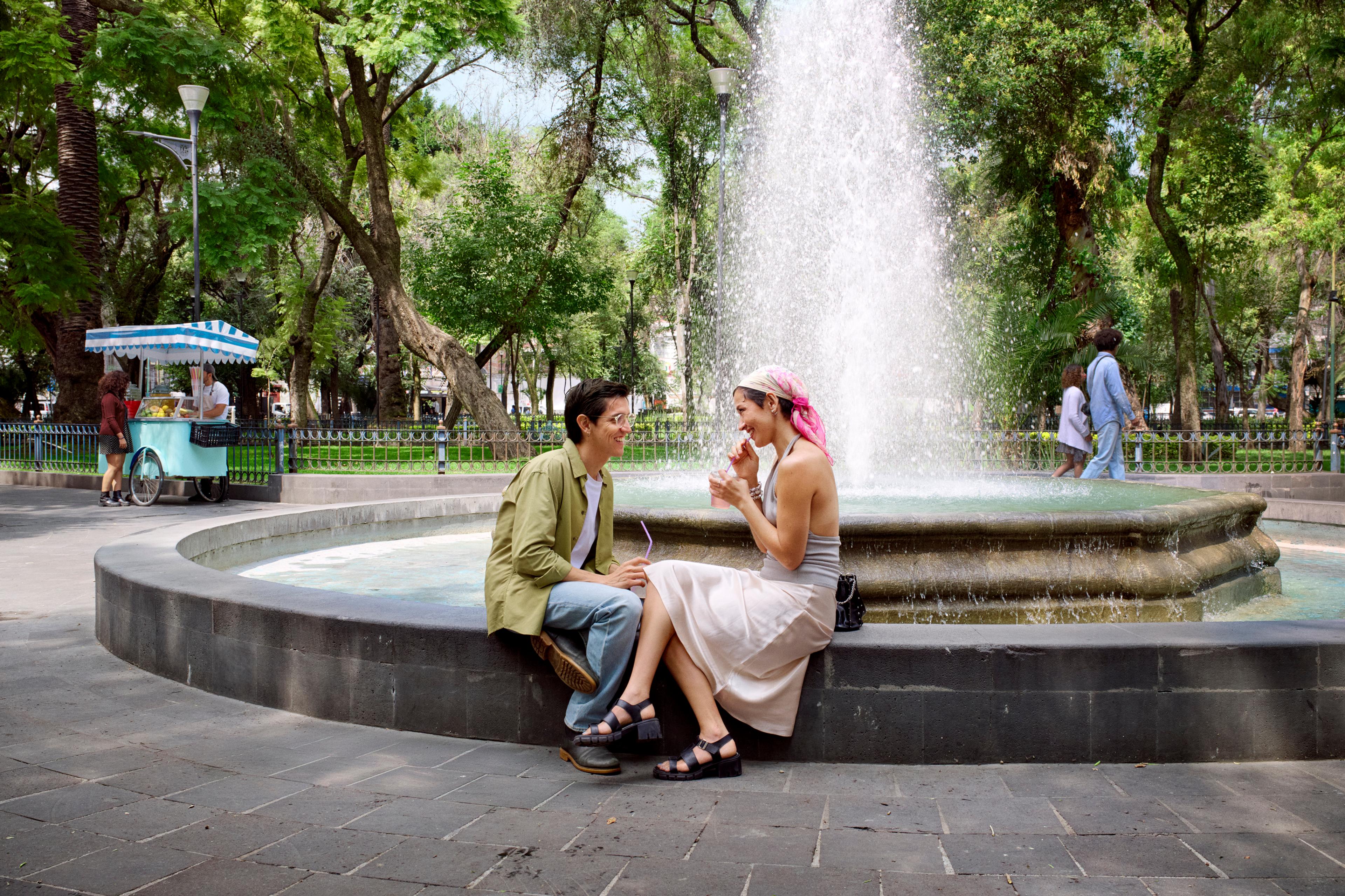 Two people sitting by a fountain