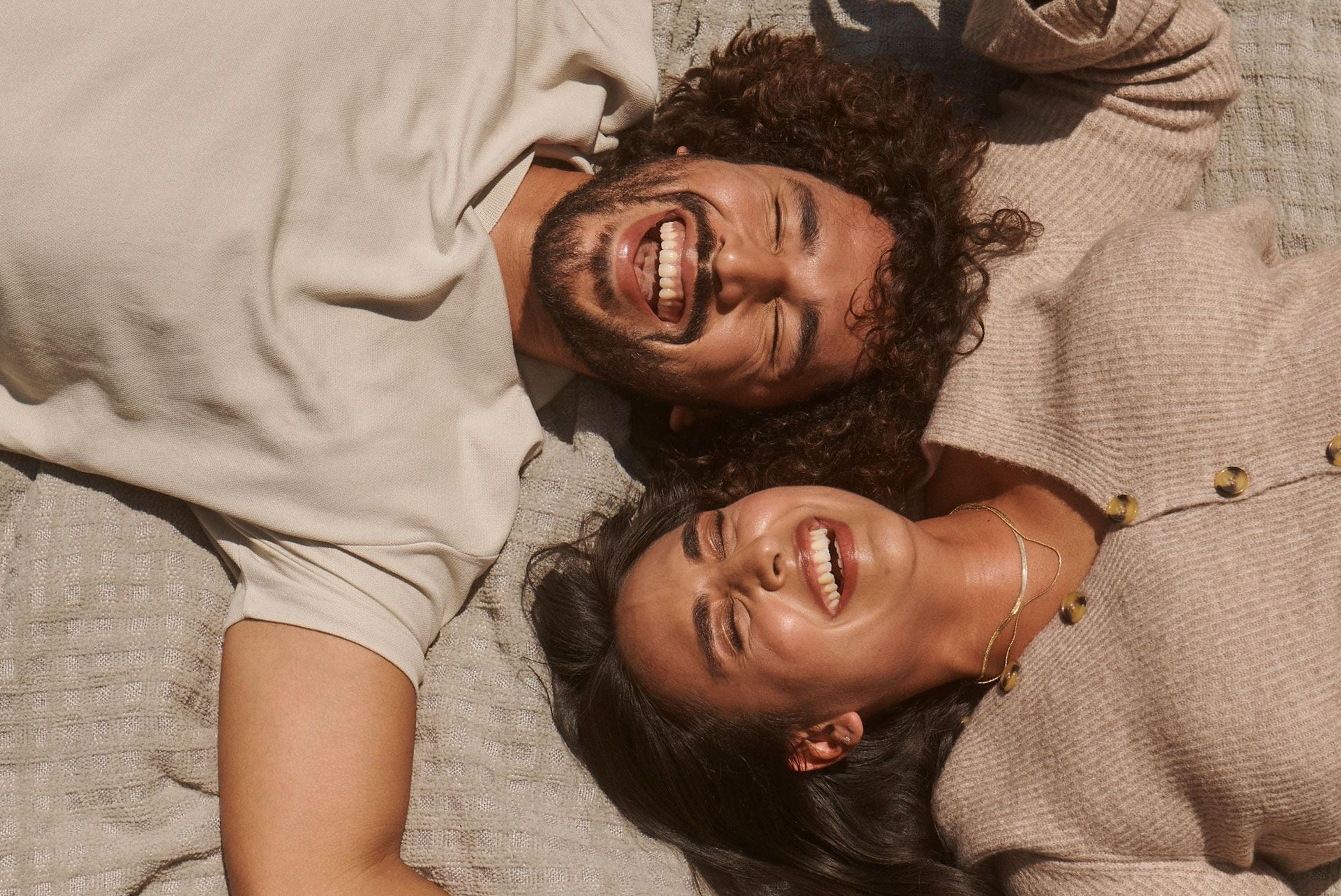 Two people lying down and laughing together (mobile)