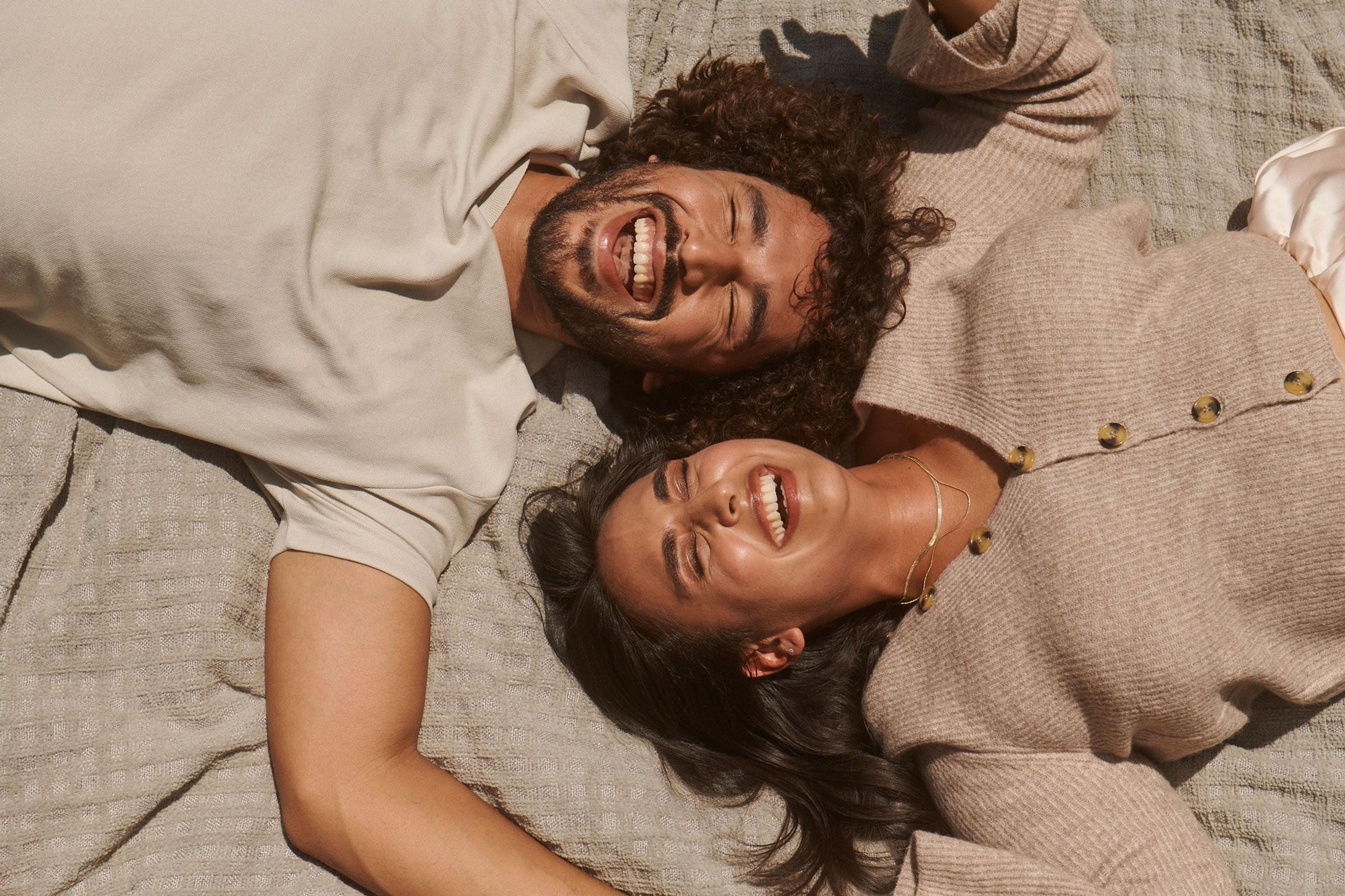 Two people laying down and laughing together