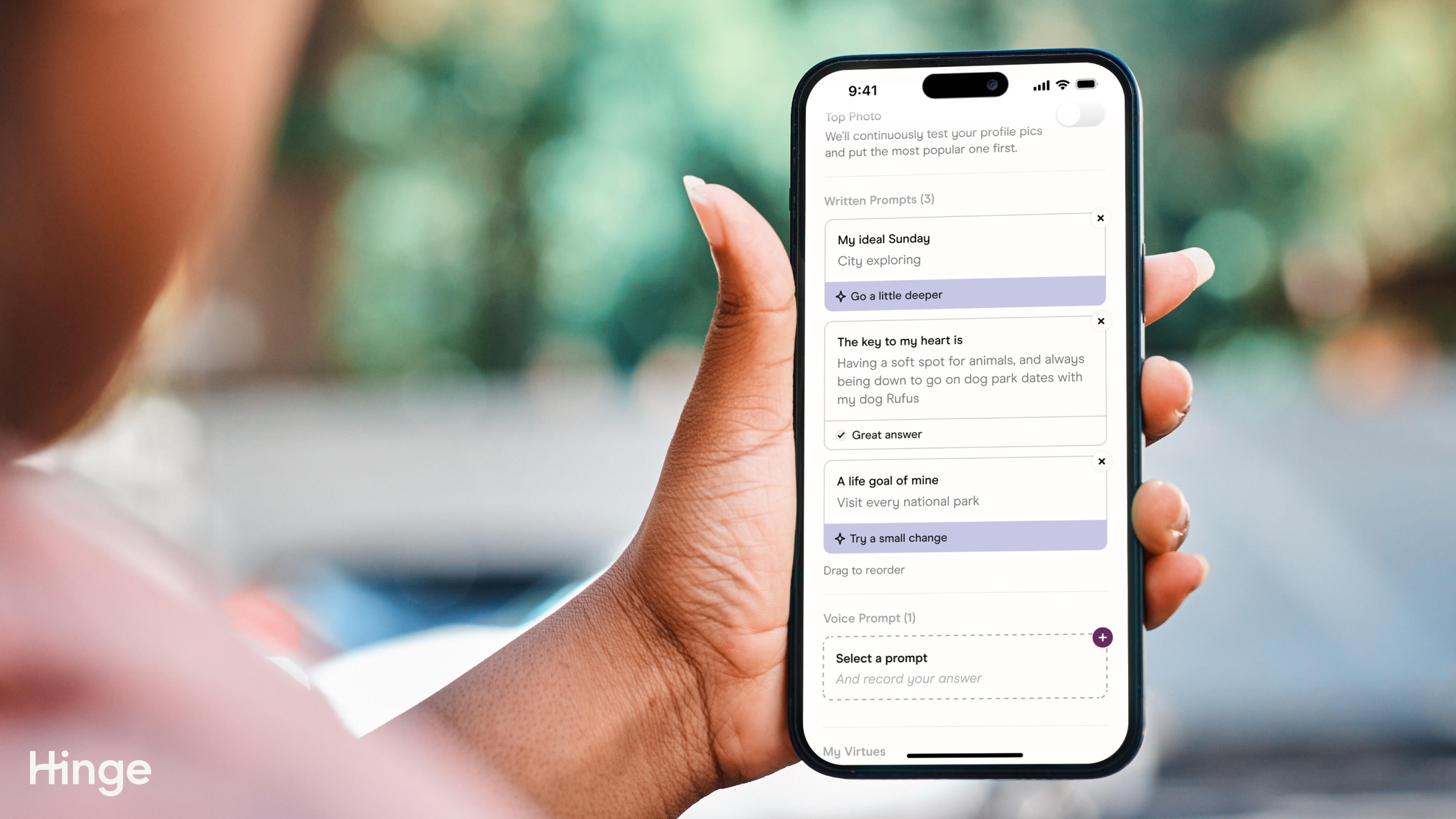 A picture of a person holding a phone. The screen shows three of Hinge's written Prompts in settings. 