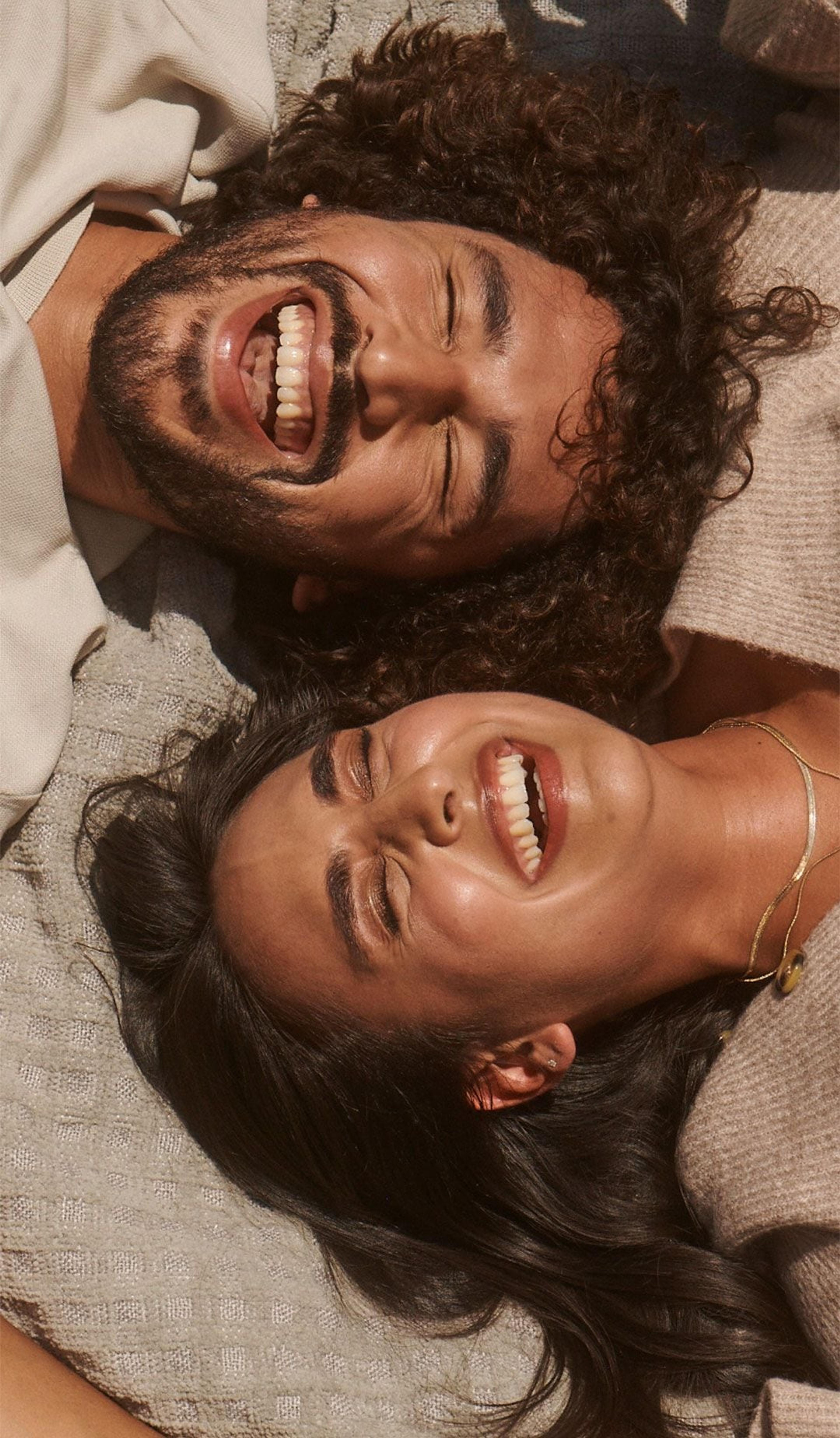 Two people laying down and laughing together