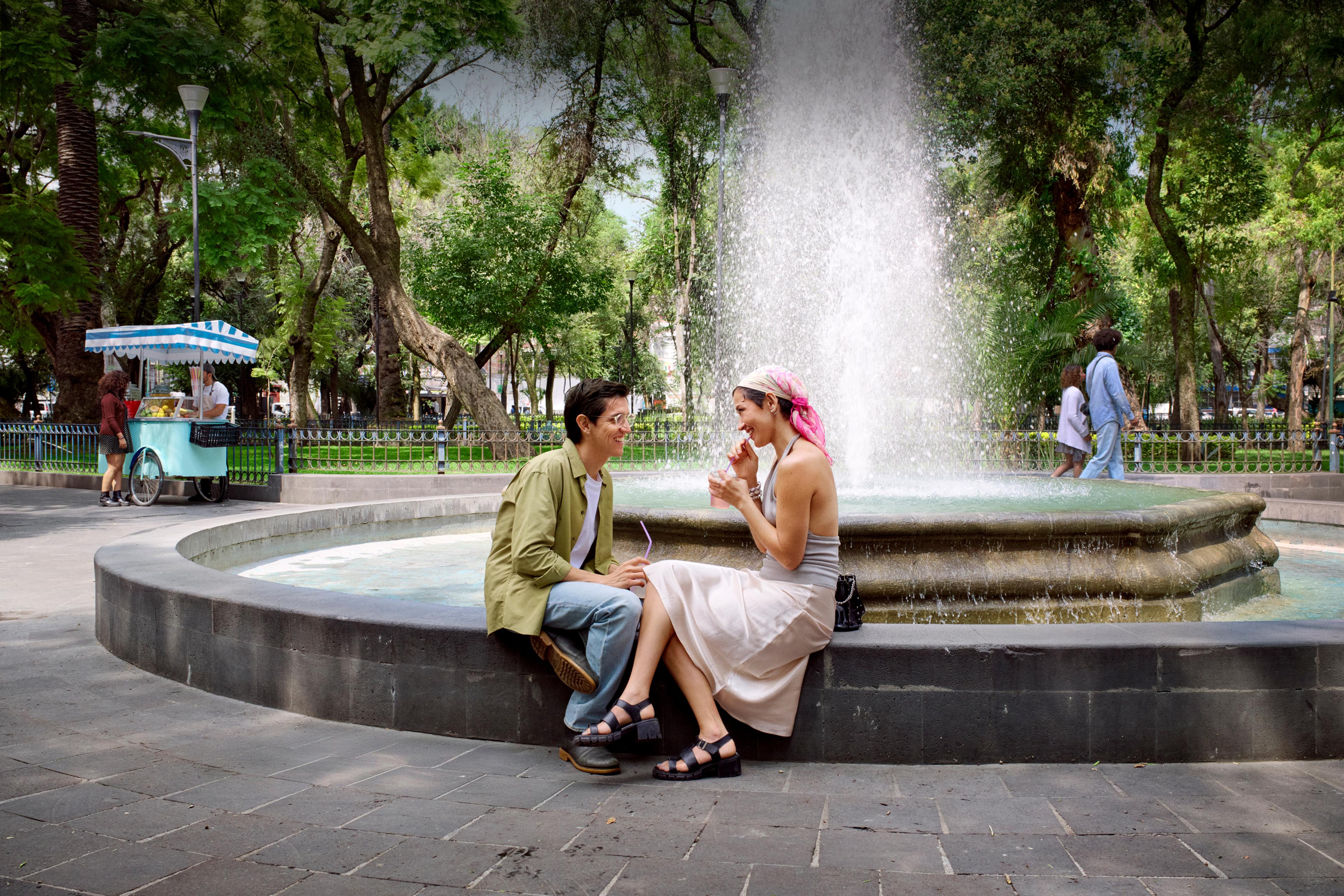 Two people sitting by a fountain