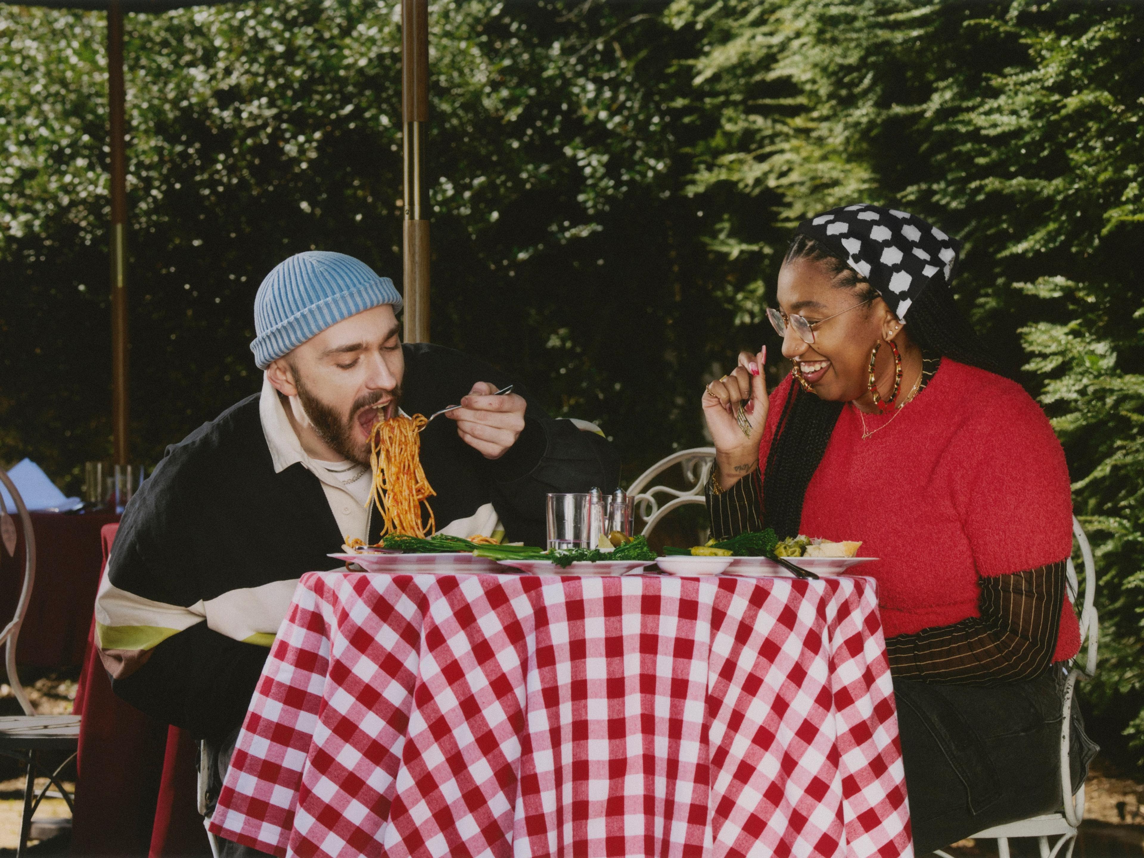 Two people sitting in a diner, looking at each other and smiling