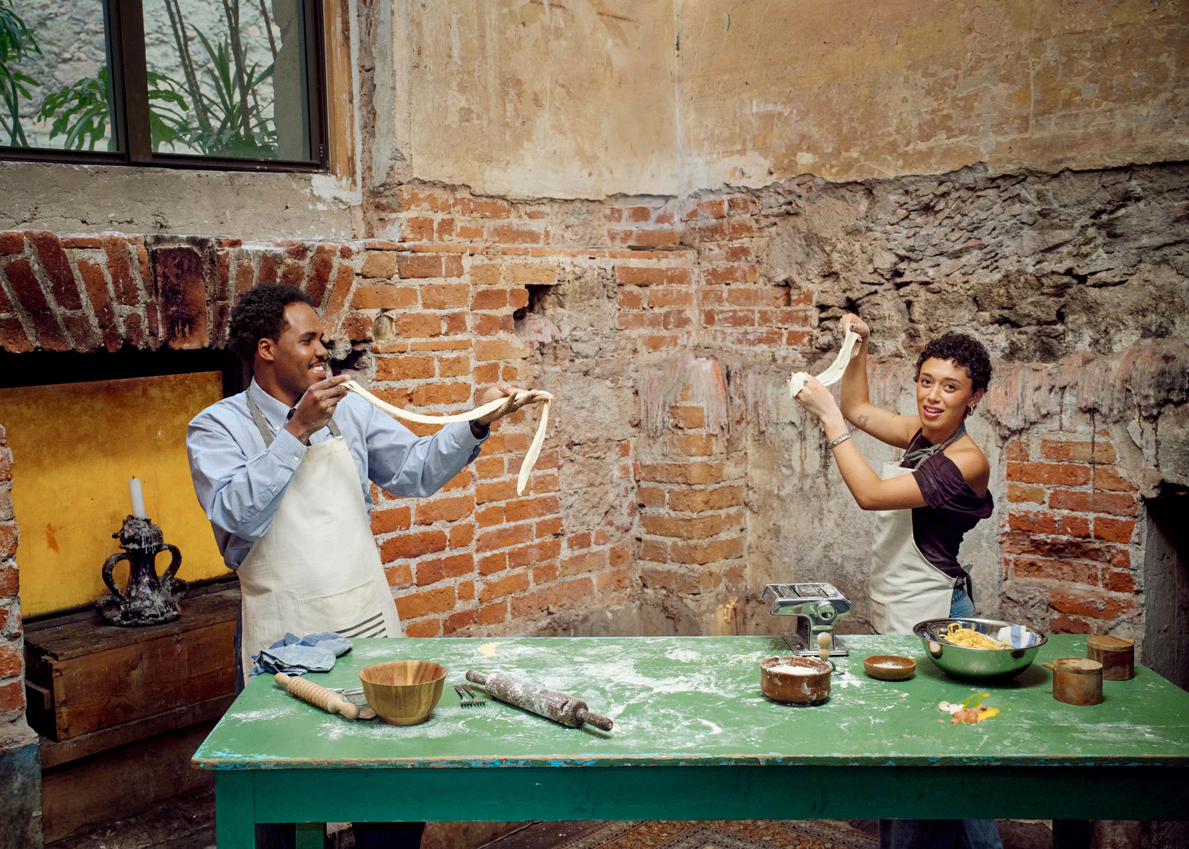 Two people standing up and making dough together (mobile)